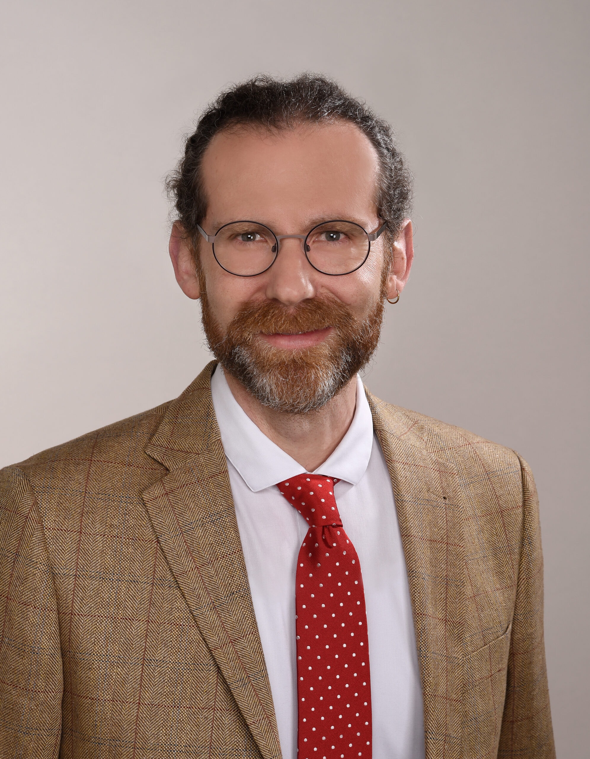 Maik Schäfer – Ein Mann mit Bart und Brille im Anzug